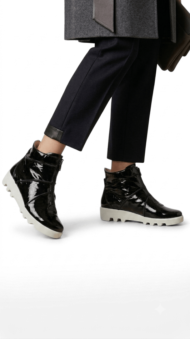 Bota feminina tratorada em couro verniz preto com zíper frontal. 