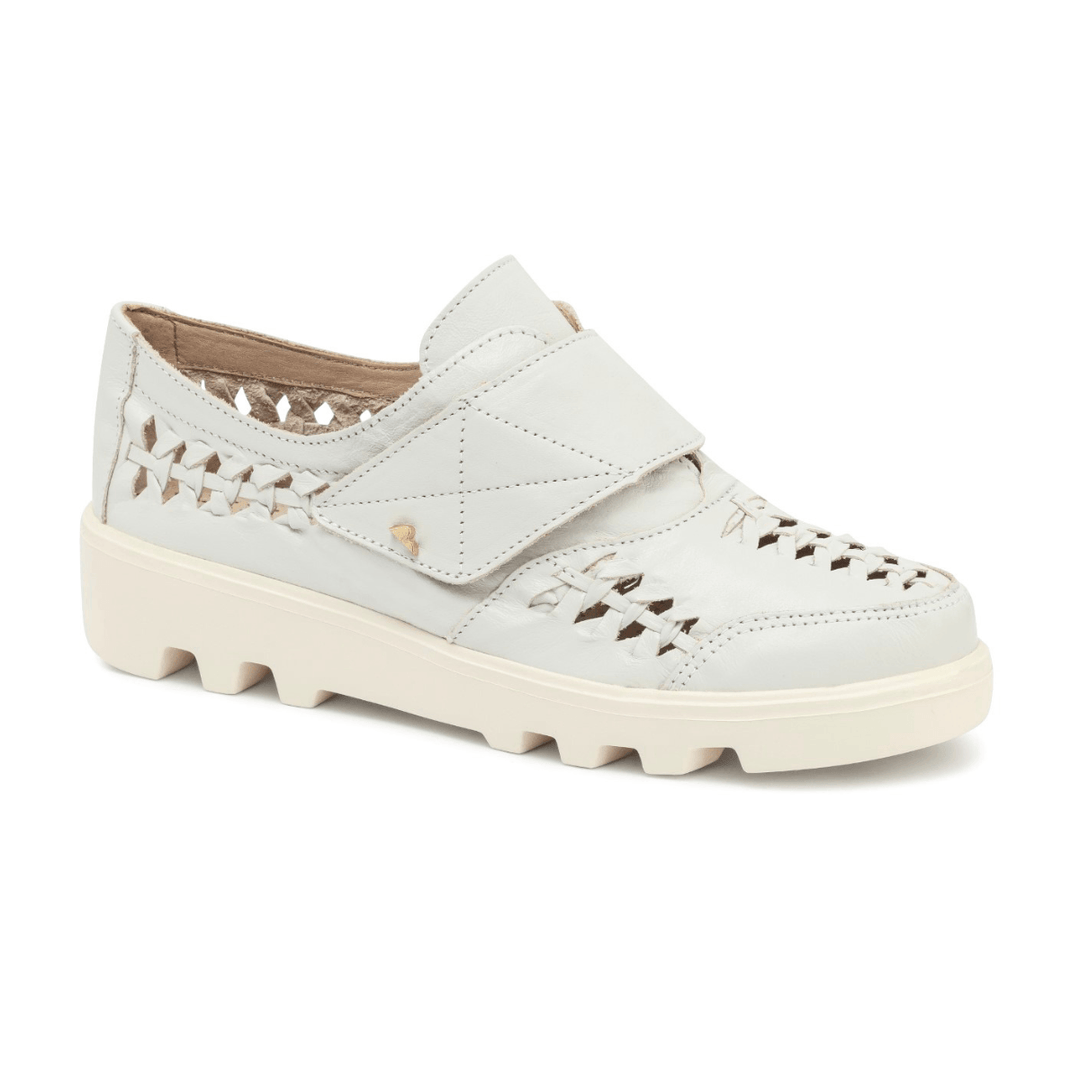 Sapato casual feminino em couro nude com recortes vazados, fechamento em velcro e solado tratorado off-white em fundo branco.